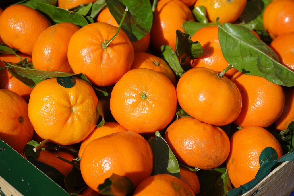 clementines in a box with leaves